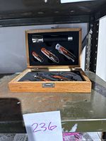 Closed wooden case with visible flashlight and tools inside