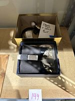 Stereoscope viewer in original box with accompanying items including a small light bulb and note showing price.