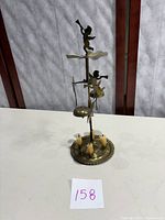 Front view of the brass angel chimes showing angel figures and circular base with candle holders