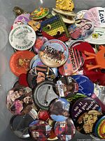 Close-up photo showing a variety of pins including Mork and Mindy, E.T., love-themed, and Edaville Railroad pins.