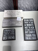Four wooden box signs displayed on table with various sayings.