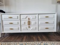 Front view of white nine-drawer dresser with gold hardware