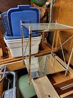 Side angle showing chrome frame and mirrored lower shelf with clear glass top, highlighting condition and structure.