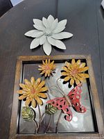 White metal flower on table, showing size and layered petal detail.