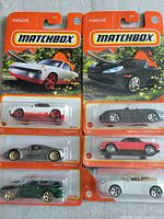 Six Matchbox Porsche cars in unopened packaging: white 914, black 911 Cabriolet, gray 918 Spyder, red 911 Cabriolet, green 911 Cabriolet, silver 1971 911