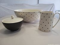 Set view showing cream and black polka dot salad bowl, cream pitcher, and black lidded sugar bowl