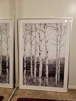 Front view of the large framed picture showing the birch tree group artwork with frame, standing upright against a wall.