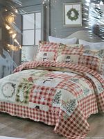 Photo showing the quilt set displayed on a bed with Christmas-themed designs including snowmen and wreaths, showcasing size and pattern details.