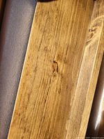 Close-up of the wood grain and color of the shelf showing the medium brown stained finish.