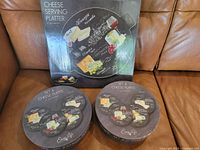 Photo showing boxed cheese serving platter and two boxes of cheese plates in their original packaging, all with Easy Life branding and cheese-themed design.