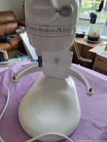 Front view of white stand mixer showing body and base with tilt-head arms