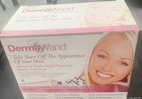 Box of DermaWand Anti-Aging Device showing promotional text and product branding.
