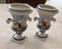 Pair of vintage Royal Delft ceramic vases with blue windmill decoration shown from front and angled side, highlighting shape and painting details