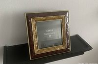 Front angled view of Bombay Company photo frame showing embellished borders and brown/gold coloration.