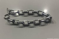 Top view photo of the bracelet laid flat showing the thickness and shape of rectangular links with toggle clasp.