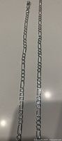 Photo showing the sterling silver bracelet and necklace set laid flat to display chain pattern and length.