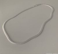 Silver-tone necklace laid flat to show full length and chain design.