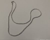 Full view of the twisted rope chain necklace laid flat and extended.