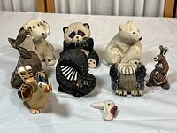 All 8 multicolored clay animal figurines arranged together showing variety and scale