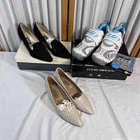 Lot showing three pairs of shoes: black Bally heels, beige Amalfi heels, and white/gray/blue Louis Garneau athletic shoes with their original boxes