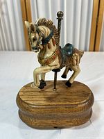 Front view of the detailed musical carousel horse figurine on a wooden base.