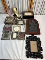 Full overview of the decorative lot including all frames, boxes, shoe sculpture, mirror frame, and glass bottle on white surface.