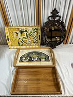 Full overview of the collection showing two decorated serving trays, one plain bamboo tray, and the ornate mirror.