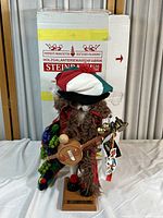 Full view of the handcrafted wood Italian Santa figurine standing on a wooden base next to its original Steinbach box.