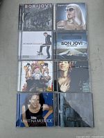 Nine music CDs arranged with visible album art including Bon Jovi, No Doubt, Justin Timberlake, Sarah McLachlan, and Martina McBride.