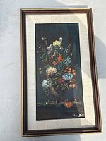 Full view of framed floral still life print featuring colorful flowers in a vase against a dark background, signed by Flora Adita in the lower right corner.