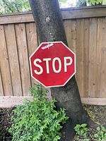 Front view of a large red octagonal metal stop sign with white letters 'STOP'.