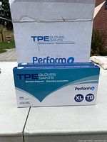 Photo of two sealed boxes of Perform TPE gloves XL size in a shipping carton.