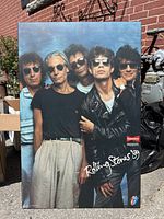 Full front view of the Rolling Stones board picture showing five band members posing outdoors with brick wall background and the Budweiser Presents 'Rolling Stones '89' print.