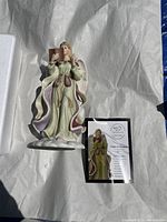 Porcelain Angel of Wisdom figurine, 9 inches tall, with certificate card on white crumpled paper.