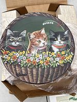 Top side view of the decorative plate showing three kittens in a flower-filled basket against a green background