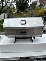 Front view of stainless steel gas burnisher with wooden handles and mounted on stand