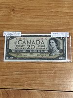 Front side of the 1954 Canadian $20 banknote featuring the Devil's Face portrait of Queen Elizabeth II with serial number visible.