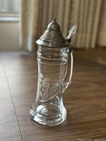 Full side view of the beer stein showing cut lead crystal body with etched design and the pewter lid.