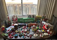 Wide view of the entire vintage Christmas holiday lot showing lights, Santa blow mold, stockings, ornaments, and miniature trees.