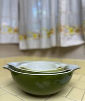 Side view of the stacked Pyrex mixing bowls showing green exterior of largest bowl and curvature of the set.