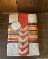 Full view of folded vintage tablecloth with stack of round capiz shell coasters on top.