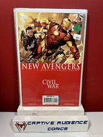 Front cover of New Avengers #25 comic book packed in protective sleeve with price stickers and Captive Audience Comics stand.