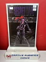 Photo of Secret War #4 comic book with foil cover featuring female character in black costume against dark background.