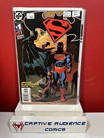 Front cover image of Superman/Batman #1 3rd print variant comic book in protective plastic sleeve with a red background and Captive Audience Comics stand.