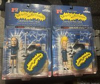 Two Beavis and Butthead figures in original sealed blister packaging, Cornholio and Beavis characters, showing front view of packaging with blue backgrounds and yellow logo.