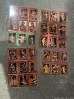 Top-down photo showing approximately 53 individual WCW wrestling cards laid out in protective sleeves on a flat surface. Cards include various wrestlers in action and pose shots with red borders.