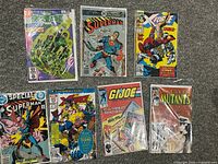 All seven older comic books shown front facing and sealed in plastic sleeves.