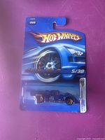Front view of 2006 Hot Wheels First Edition Ferrari 512M in original packaging showing blue car with number 6 and Hot Wheels branding