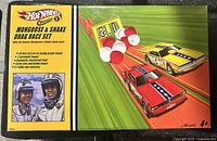 Front of box showing Hot Wheels Classics Mongoose & Snake Drag Race Set with picture of cars and racers.
