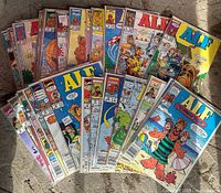 Top-down view of 26 Alf comic books by Marvel Comics, all bagged on cards, arranged in overlapping fan pattern on floor.